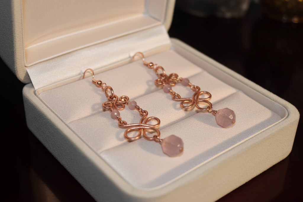 Madagascar Rose Quartz copper infinity loop earrings in cream velvet jewelry box