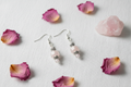 Flat lay of Madagascar Rose Quartz sterling silver earrings on white linen